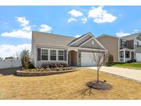 Charming single-story home featuring a manicured lawn and stone-lined flower bed, plus an attached garage at 11 S Great White Way, Clayton, NC 27527