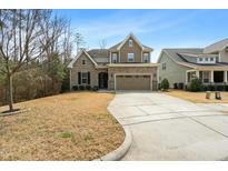 Charming two-story home featuring stone accents, a well-manicured lawn, and a spacious driveway at 137 Fawnwood Acres Dr, Apex, NC 27539