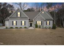 Charming one-story home with stone accents, symmetrical windows, and a well-manicured lawn at 203 Mitchell Manor Dr, Angier, NC 27501