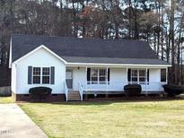 Charming single-story home with white siding, dark shutters, and a welcoming front porch at 212 Davis Farm Dr, Selma, NC 27576