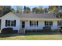 Charming single-story home featuring a covered front porch and well-maintained landscaping at 212 Davis Farm Dr, Selma, NC 27576