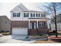 Inviting two-story home with brick facade, manicured landscaping, and a two-car garage at 212 Liberty Rose Dr, Morrisville, NC 27560