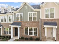 Charming exterior view of newly built townhomes, showcasing a mix of brick and siding finishes and inviting front entrances at 223 Frosted Iris Lane Ln # 176, Garner, NC 27529