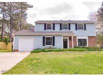 Charming two-story home with light blue siding, black shutters, and a well-maintained front yard at 2513 Boothbay Ct, Raleigh, NC 27613