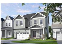 Charming two-story home with gray siding, a covered porch and an attached two-car garage at 301 Beacon Dr, Pittsboro, NC 27312