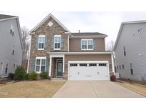 Charming two-story home with a stone accent wall, blue shutters, and a well-maintained front yard at 311 Silverhawk Ln, Durham, NC 27703
