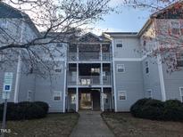 A light gray condo building featuring a two-level porch and accessible parking in a quiet neighborhood at 3710 Pardue Woods Pl # 103, Raleigh, NC 27606