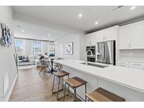 Modern kitchen featuring white cabinets, stainless steel appliances, and a spacious island with seating at 600 Hedrick Ridge Road # 104, Cary, NC 27519