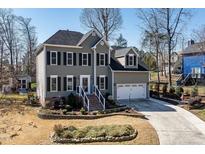 Charming two-story home with a well-manicured front yard, black shutters, and an attached two-car garage at 604 Chadbourne Dr, Durham, NC 27703