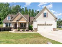 Charming home featuring manicured lawn and a two-car garage, blending comfort and curb appeal at 70 Breadnut Dr, Smithfield, NC 27577