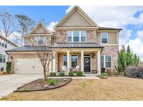 Inviting two-story home with a stone facade, manicured lawn, and a charming front porch at 156 Greenhurst Cir, Holly Springs, NC 27540