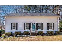 Charming single-story home with a blue door, black shutters, and a well-manicured front yard at 166 Creek Dr, Louisburg, NC 27549