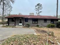 Charming log cabin home with red roof and well-maintained landscaping at 182 Tree Cutters, Sanford, NC 27332