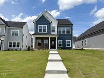 Charming two-story home with blue siding, white trim, and a well-manicured lawn under a partly cloudy sky at 269 Marvel Dr # 138, Rolesville, NC 27571