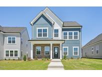 Charming two-story home featuring blue siding, brick accents, a well-manicured lawn, and a welcoming front porch at 269 Marvel Dr # 138, Rolesville, NC 27571