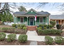 Charming green bungalow featuring a welcoming front porch and manicured landscaping at 603 Polk St, Raleigh, NC 27604