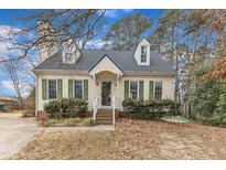 Charming single-Gathering home featuring a well-manicured lawn, dormer windows, and a cozy front porch at 6100 River Laurel Ct, Raleigh, NC 27604