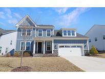 Charming two-story home boasts board and batten siding, stone accents, and an attached two-car garage at 624 Red Arrow Dr, Knightdale, NC 27545