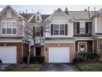 Charming multi-level townhome featuring an attached garage and manicured landscaping at 7031 Racine Way, Raleigh, NC 27615