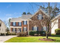 Charming two-story brick home with blue shutters, well-manicured lawn, and inviting front porch at 9344 Palm Bay Cir, Raleigh, NC 27617