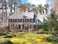 Charming brick home with blue shutters, lush landscaping, and a manicured front lawn creating curb appeal at 10005 Avocado Cir, Raleigh, NC 27615