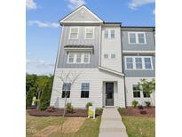 Inviting townhome with a modern, gray and white facade, complemented by well-maintained landscaping at 1035 Zelkova Ln, Chapel Hill, NC 27517