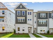 New two-story home featuring gray and white accents, situated on a neatly manicured lawn at 1035 Zelkova Ln, Chapel Hill, NC 27517