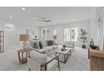 Bright living room featuring neutral tones, a comfortable sofa, and ample natural light from multiple windows at 116 Pointe Park Cir, Holly Springs, NC 27540