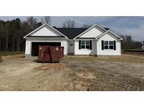 Charming single-story home with a white facade, dark shutters, and an attached garage on a spacious lot at 164 Jones Creek Ln, Lillington, NC 27546
