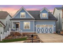 Charming blue two-story home featuring a well-manicured lawn and a two-car garage at 2245 Dunlin Ln, Raleigh, NC 27614