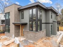 Modern two-story home featuring mixed material exterior, large windows, and an inviting entryway at 2305 Turners Aly, Raleigh, NC 27607