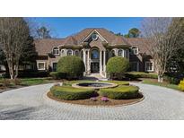 Stunning brick home featuring a circular driveway, well-manicured landscaping, and classic architectural details at 2421 Acanthus Dr, Wake Forest, NC 27587