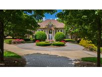 Stately brick home featuring a circular driveway with fountain and manicured landscaping at 2421 Acanthus Dr, Wake Forest, NC 27587