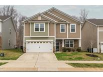 Two-story home with a two-car garage, stone accents, neutral siding and a well-manicured lawn at 516 Spaulding St, Burlington, NC 27215