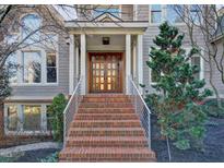 A beautiful exterior shot of a gray two-story house with a brick staircase leading to the elegant wood front door at 805 Greenwood Rd, Chapel Hill, NC 27514