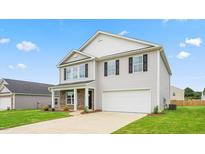 Charming two-story home with a manicured lawn and a two-car garage at 857 Forth Ct, Gibsonville, NC 27249