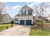 Two-story home features a two-car garage, blue shutters, and a well-manicured lawn at 917 Widewaters Pkwy, Knightdale, NC 27545