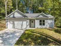 Charming single-story home features a one car garage, a yard and a concrete driveway at 107 Cochise Dr, Louisburg, NC 27549