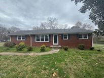 Charming brick home featuring a well-maintained front yard and classic architectural details at 1618 Gerringer Mill Rd, Burlington, NC 27217