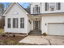 Charming front exterior with decorative door, arched windows, attached garage, and tasteful landscaping at 173 Allie Dr, Garner, NC 27529