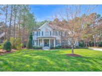 Charming two-story home with manicured lawn, mature trees, and a welcoming front porch at 204 Dartmoor Ln, Raleigh, NC 27614