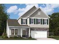 Charming two-story home with stone accents, gray siding, green shutters, and attached two-car garage at 3216 Shannon Woods Lane # 16, Apex, NC 27523