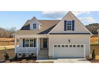 Charming home featuring white siding, blue shutters, and an attached two-car garage at 336 Pecan Valley Way, Four Oaks, NC 27524