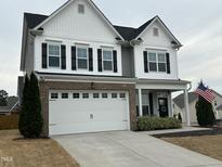 Charming two-story home featuring a white exterior, two-car garage, black shutters, and an inviting front porch at 365 Rocky Crest Ln, Wake Forest, NC 27587