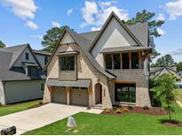 New two-story home boasts a manicured lawn, brickwork and a three-car garage at 3727 Bellevue Rd, Raleigh, NC 27609