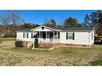 Cozy, single-story home with a covered porch and tidy landscaping at 59 Willow Lake Rd, Roxboro, NC 27574