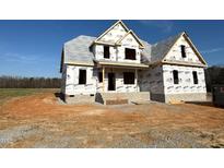 Exterior view of a two-story home under construction with a covered porch and unfinished yard at 70 Prency Ln, Middlesex, NC 27557