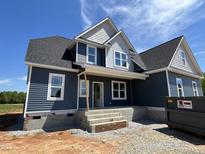 Two-story home features blue siding, white trim, black shingle roof, and a welcoming covered front entrance at 70 Prency Ln, Middlesex, NC 27557
