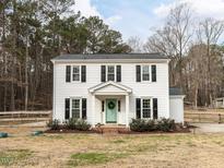 Charming two-story home with white siding, black shutters, and a well-manicured lawn at 7408 Stable End Rd, Raleigh, NC 27613