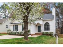 Charming single-story home featuring a blossoming tree, landscaped yard, and inviting entrance at 936 Amersham Ln, Wake Forest, NC 27587